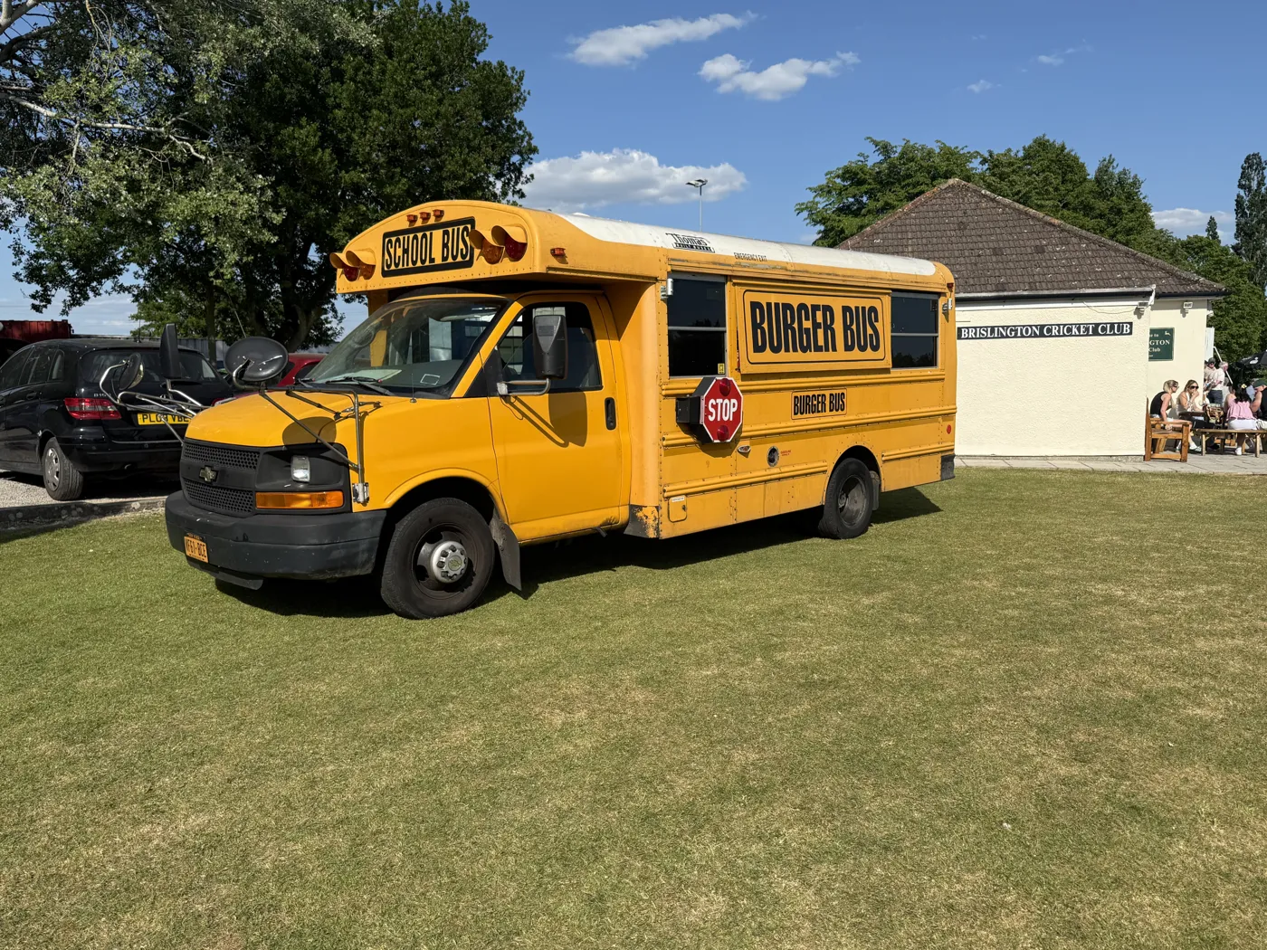 The yellow Burger Bus parked on the grass at a venue